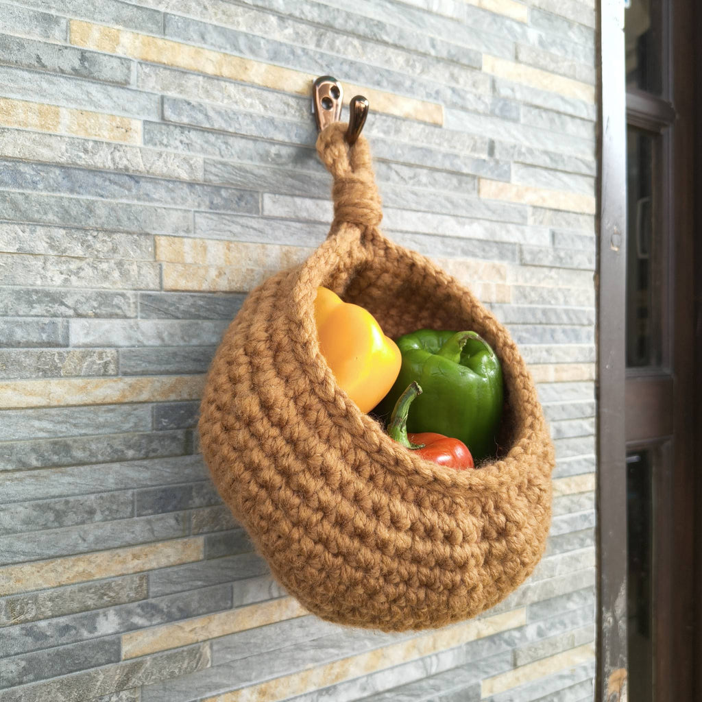 Brown woven basket with peppers on a stone surface